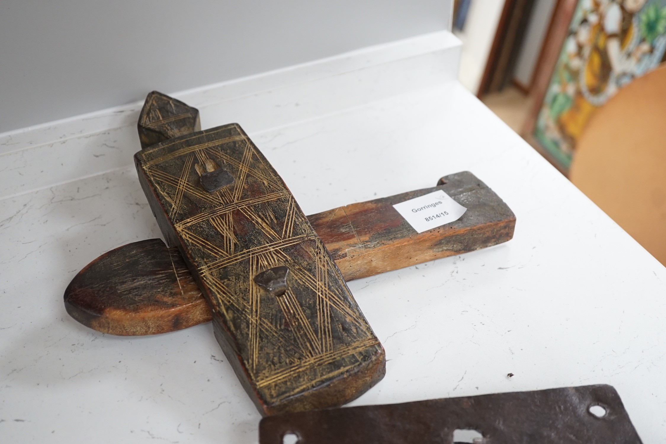 Three early ironwork lock plates with keys and a carved hardwood bolting lock